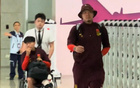 國足抵渝，胡荷韜坐輪椅，王大雷招手致意。